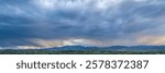 dramatic storm clouds at dusk over Rocky Mountains and lake in northern Colorado