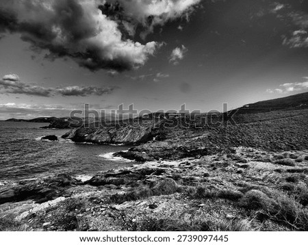 Dramatic storm clouds gathering above a rugged Mediterranean coastline in Greece. Stylised landscape with strong contrast and textured skies, suitable for weather editorial, climate change features, e