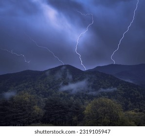 Dramatic storm clouds illuminated by intense lightning strikes.