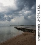 The dramatic storm clouds loom over top a lonely light post on a pier in Orillia, Ontario, Canada