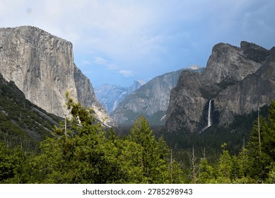 Dramatic storm clouds and a looming thunderstorm build over Yosemite Valley in Yosemite National Park, California. Iconic granite cliffs including El Capitan and Half Dome stand powerful against the darkening sky, capturing the raw majesty and ever-changing weather of one of America’s most beloved national parks. This powerful moment highlights nature’s dramatic forces over the iconic landscape.