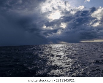 Dramatic Storm Clouds Over Dark Ocean with Sunlight Reflection