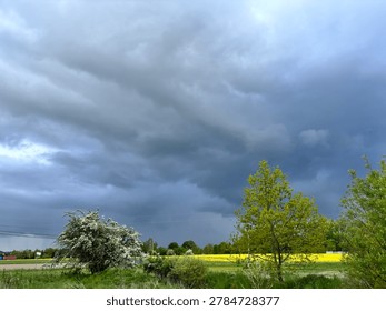 Dramatic storm clouds over a green agricultural field, impending rain weather landscape.