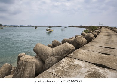 Dramatic storm clouds over manmade wave breaker with fishing boats in Marang Terengganu