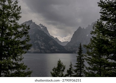 Dramatic storm clouds over the Teton mountain range reflected in Jenny Lake, Grand Teton National Park, Wyoming, USA