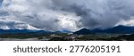 Dramatic storm clouds rolling over the Fraser Valley river floodplain and mountains; Cloudscape in Fraser Valley, British Columbia, Canada.