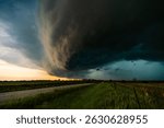 Dramatic storm sweeps across fields and farmland with heavy wind and rain, dark clouds moving fast, creating an ominous, moody sky filled with texture, shadow, and epic weather atmosphere