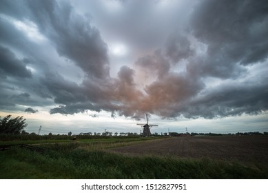 Dramatic stormclouds over a lone windmill in the countryside of Holland