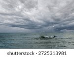 Dramatic stormy dark grey sky over cold ocean seascape with flyi