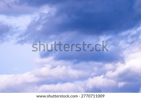 dramatic stormy sky with heavy dark clouds gathering over horizon, moody atmosphere, natural weather background, powerful light contrasts, impending rain, Nature shows dramatic and powerful mood