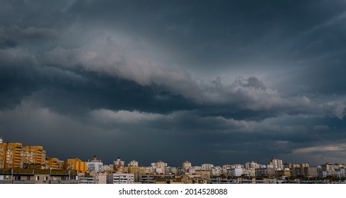 Dramatic stormy sky over modern city residential district. Low angle panorama.