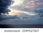 Dramatic stormy sky over the North Sea in Bredene, Belgium, with pastel hues breaking through the clouds.
