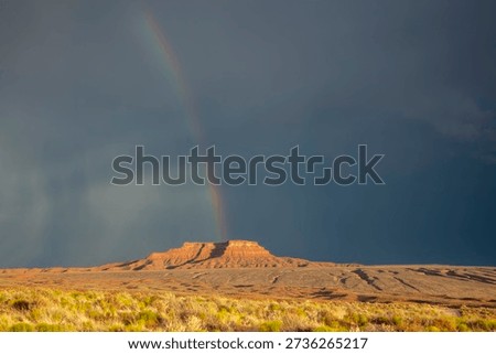 Dramatic stormy sky's over butte with rainbow in Valley of the Gods in Utah