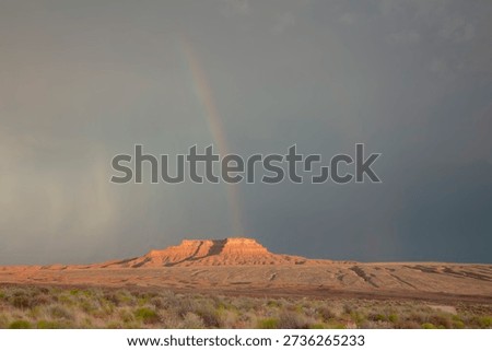Dramatic stormy sky's over butte with rainbow in Valley of the Gods in Utah