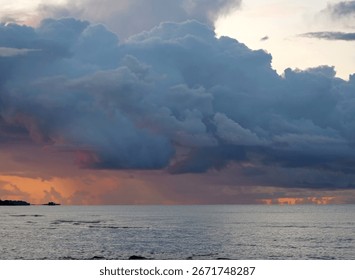 Dramatic stormy sunset clouds - Powerful evening sky weather - An epic and dramatic close-up of heavy storm clouds building at sunset, with a hint of orange light below