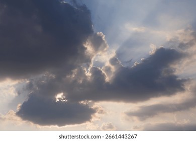 Dramatic Sun Rays Breaking Through Dark Clouds in a Blue Sky