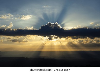 Dramatic Sun Rays Breaking Through Storm Clouds Over Desert Valley