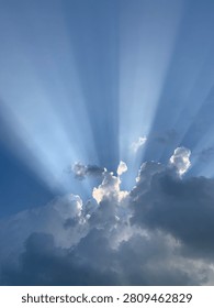 Dramatic Sun Rays Breaking Through Storm Clouds Against a Blue Sky