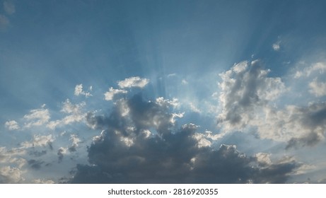 Dramatic Sun Rays Breaking Through Clouds in Blue Sky, Crepuscular Sunbeams Light Beam Background, Hope and Divine Light Concept.