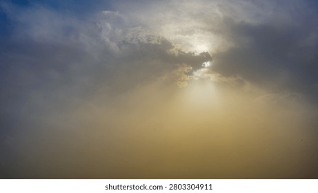 Dramatic sunbeams pierce through dark clouds during a vibrant sunset, creating a hopeful and atmospheric scene.