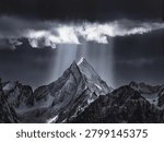 Dramatic Sunbeams Piercing Storm Clouds Over Snow-Covered Mountain Peak