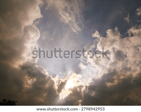 Dramatic Sunlight Breaking Through Storm Clouds Over Open Sky With Radiant Sun Rays