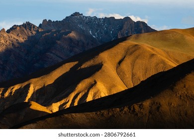 Dramatic sunlight casts shadows on the Zanskar Range in Ladakh.