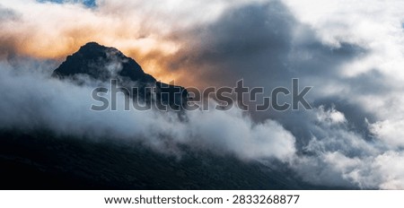 Dramatic sunrise cloudscape over the Chugach Mountains summit glacial rock formation in Anchorage Alaska viewed from Glen Alps Hiking Trail