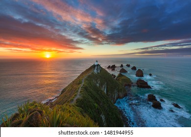 Dramatic sunrise at Nugget Point Catlins, Otago New Zealand. Looking out over the sea with waves breaking against the rocks and cliffs to either side. - Powered by Shutterstock