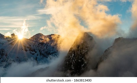 Dramatic sunset above clouds within high alpine peaks, Saas-Fee, Switzerland, Europe