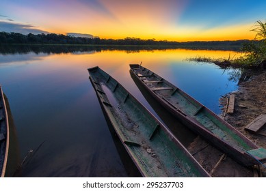 Dramatic sunset in the Amazon rain forest in Bolivia in Madidi National Park with two canoes in the foreground