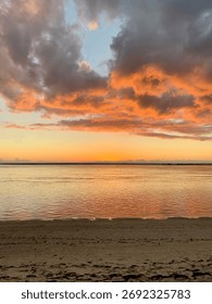 Dramatic Sunset At The Beach With Orange Sky And Still Water