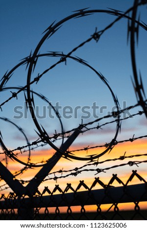 Similar – Fence with a barbed