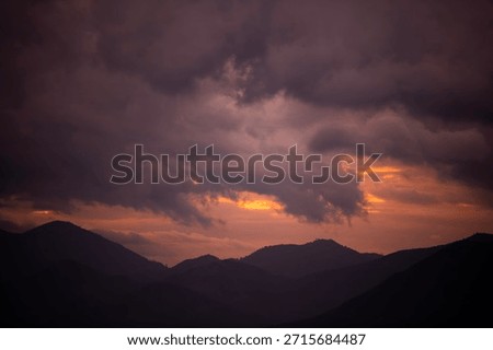 Dramatic  sunset  clouds after storm over the silhouette mountains .