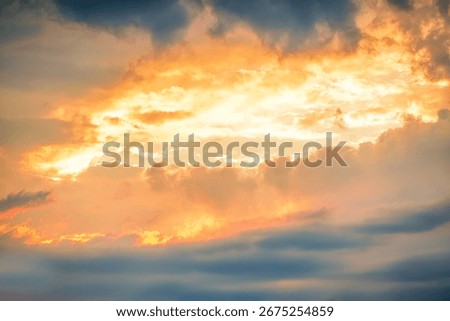 Dramatic sunset clouds creating a vivid canvas of vibrant colors in the evening sky over a tranquil landscape