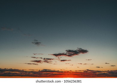 Dramatic sunset clouds landscape. Red sun. Orange light with dark clouds. Copy space.