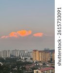 Dramatic sunset clouds over city skyline. Urban landscape with glowing orange clouds and high-rise buildings at dusk