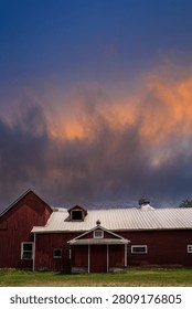 Dramatic sunset cloudscape over an abandoned barn in the mountain range of New England, a beautiful and atmospheric summer landscape in the United States of America