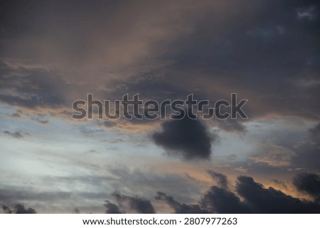 Dramatic Sunset Horizon with Last Sunbeams Peeking Through Dark Clouds over the Sea
