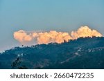 Dramatic sunset light on a large cloud over a hill in Meghalaya. 