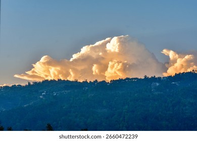 Dramatic sunset light on a large cloud over a hill in Meghalaya. 