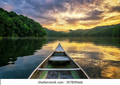 A dramatic sunset from an old canoe on a clam mountain lake in the Appalachian Mountains of Kentucky.