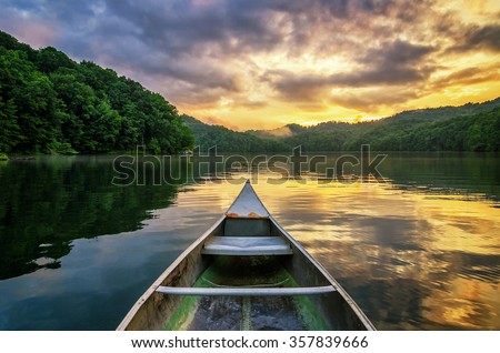 A dramatic sunset from an old canoe on a clam mountain lake in the Appalachian Mountains of Kentucky.