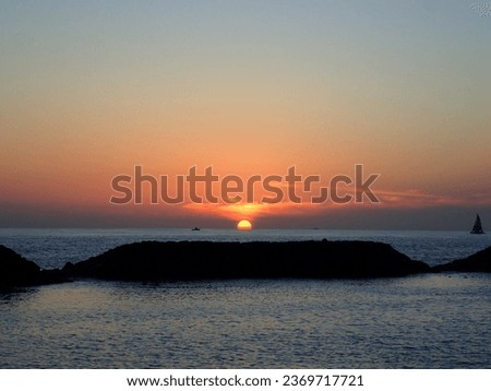 Dramatic Sunset on Magic Island Beach over the ocean with boats sailing on the water on Oahu, Hawaii. February 2015.
