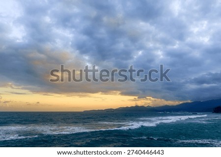 Dramatic Sunset Over Bali Coastline with Ocean Waves
