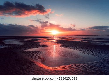 Dramatic sunset over Camber Sands beach in East Sussex, UK