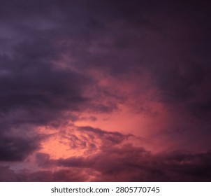 Dramatic sunset over a dark landscape with fiery clouds, atmosph