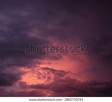 Dramatic sunset over a dark landscape with fiery clouds, atmosph