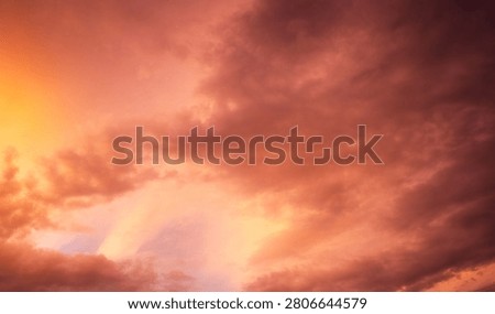 Dramatic sunset over a dark landscape with fiery clouds, atmosph