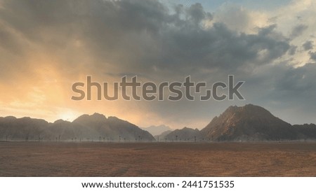 Dramatic sunset over desert landscape with mountain silhouette and cloudy sky. Scenic panoramic vibrant wallpaper.